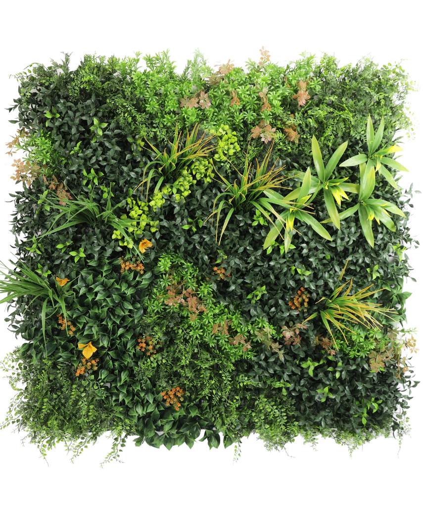 Die künstliche Hecke Marisa 100x100 cm UV ist eine üppige, quadratische grüne Wand mit gemischten Blattpflanzen, Farnen, gelbgrünen Akzenten und vereinzelten bräunlichen Blättern vor einem schlichten weißen Hintergrund.