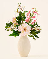 In einer cremefarbenen Keramikvase befindet sich der Strauß „Light & Lovely“ mit künstlichen Seidenblumen von Easyplants, bestehend aus einem gemischten Arrangement aus weißen, rosa und hellvioletten Seidenblumen mit grünen Blättern, vor einem schlichten, hellen Hintergrund.